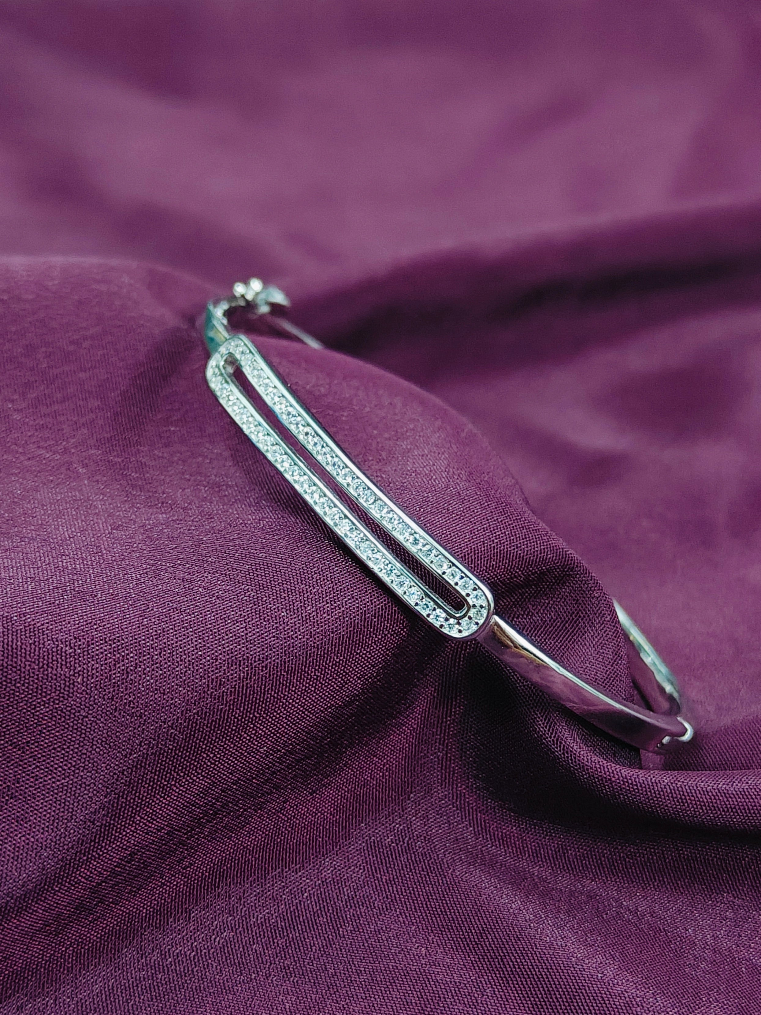 Silver brooch on a purple fabric background
